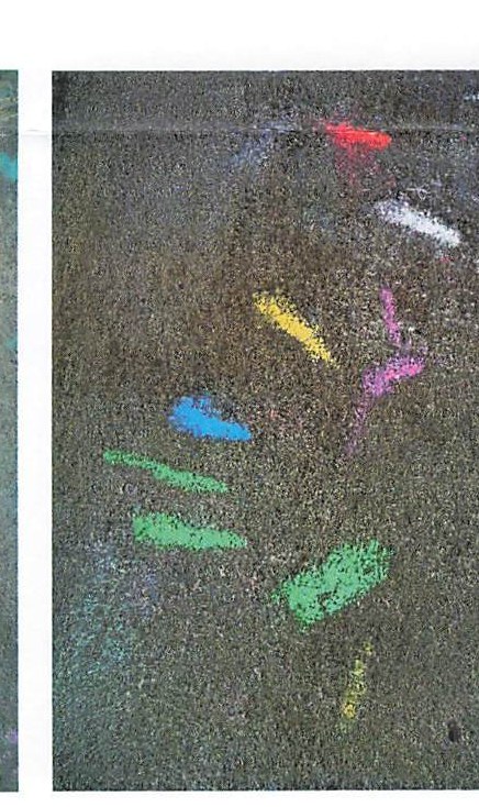 Bright chalk marks scattered across dark pavement.